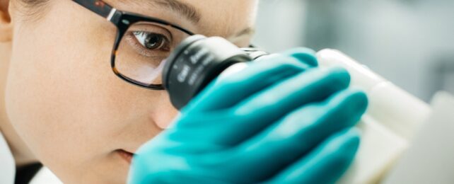 Female Scientist Looking Through Microscope