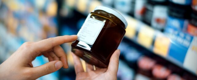 Hands Hold Jar In Supermarket