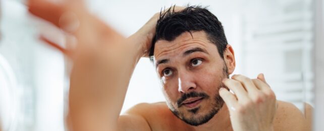 Man Checks Hair In Mirror