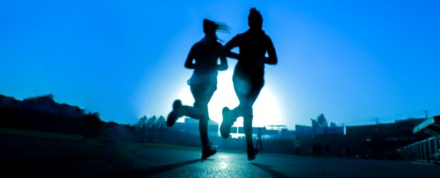 Two People Jogging On Road