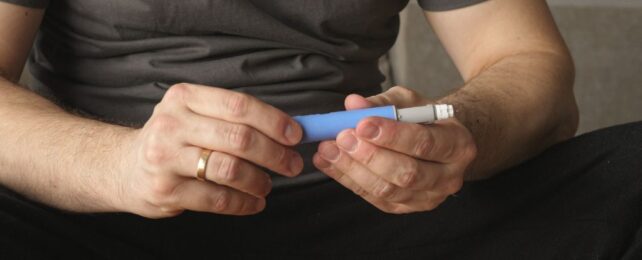 Person holding a syringe