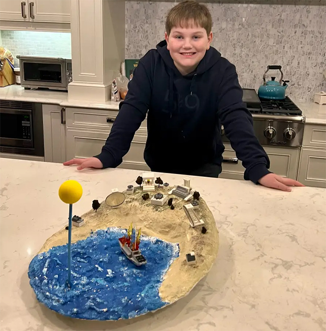 middle school student and a diorama of archimedes death ray