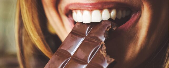 Smiling mouth eating a block of chocolate