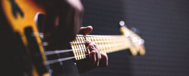 closeup of someone playing bass guitar