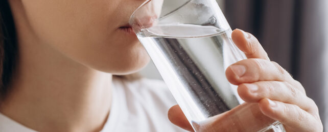 女人用玻璃杯喝水