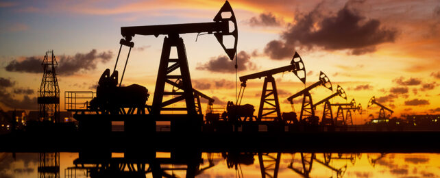 oil derricks silhouetted against the sunset