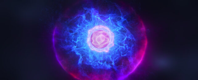 Abstract illustration of an atom with a pinkish nucleus at its core, surrounded by cloud of electrons in blue.