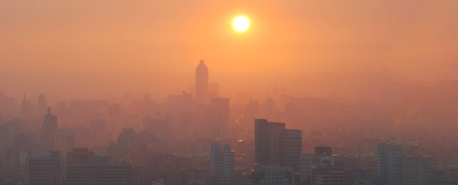 city in orange sun light lit smog haze