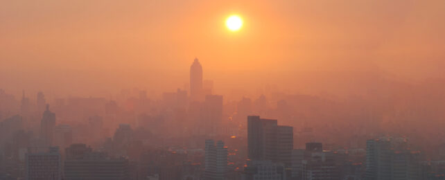 city in orange sun light lit smog haze