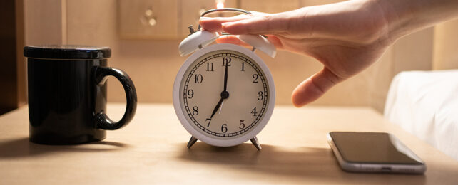 hand hitting an alarm clock