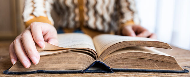 hand turning page of an old book