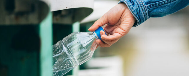 hand on plastic bottle putting it in the bin