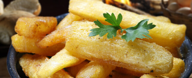fried cassava chips in pot garnished with green leaves