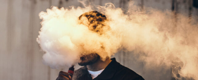 Head of vaping human in a cloud