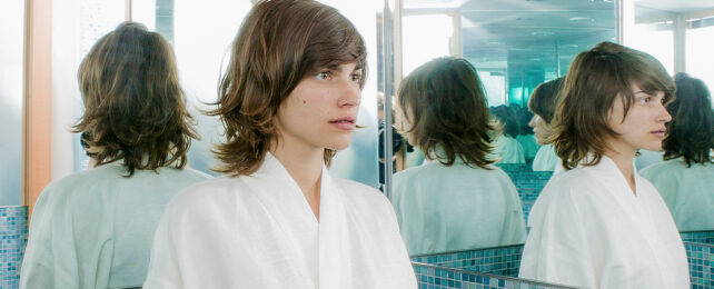 boy standing at a junction of mirrors