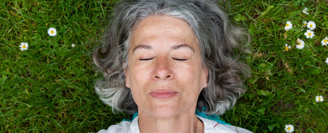 woman laying on grass with her eyes closed