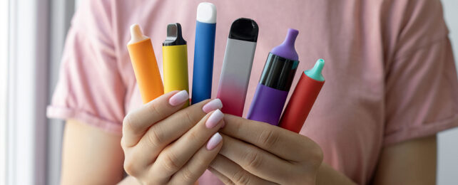 hands holding a selection of different shaped e-cig vapes