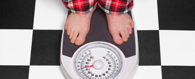 man's feet on scales on checkered floor