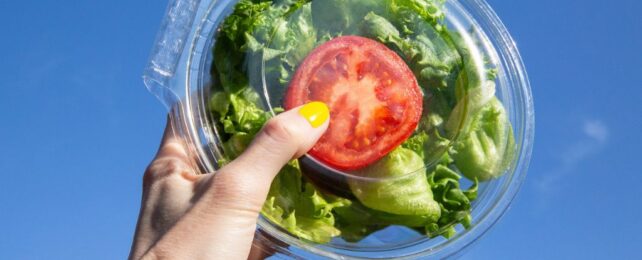 A hand holding salad