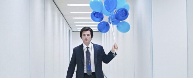 Actor Adam Scott in a business suite holding blue balloons in a very long white office hallway