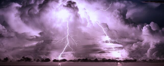 Purple-toned clouds and two lightning strikes