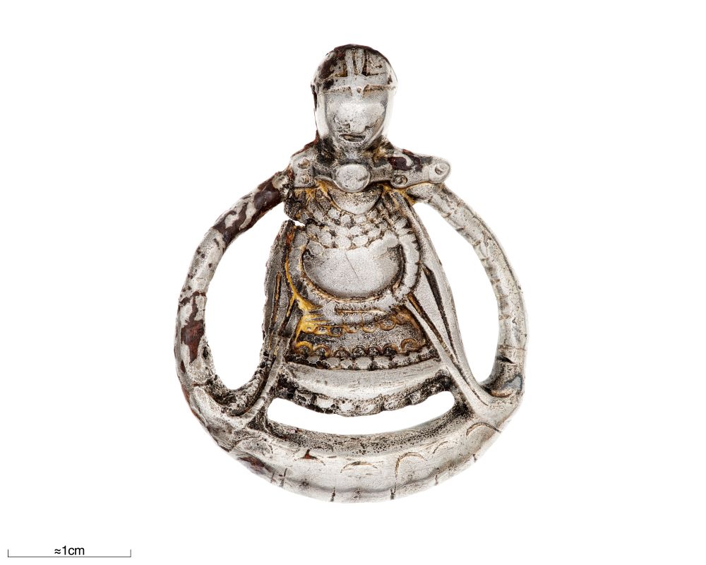 a silver pendant comprised of a metal circular shape, containing a metal figurine with a round belly, who appears to be wearing a helmet