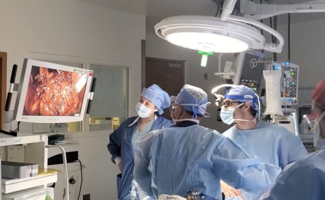 Medical team in blue scrubs looking at screen with bladder on it