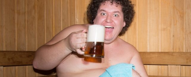 man drinking beer in a sauna