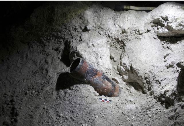 A pot lying in sandy ground