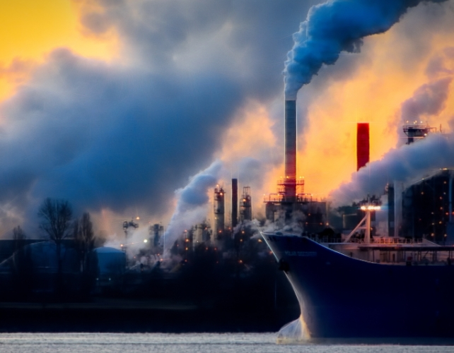 smoke stacks and a ship