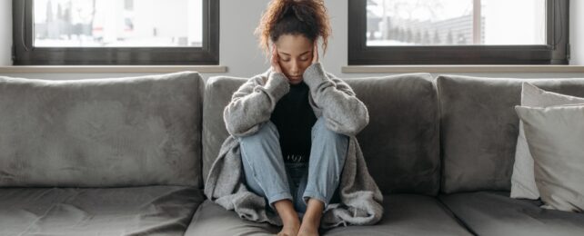 woman sitting holding her head