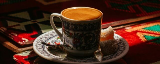 Coffee mug and saucer on bright red table