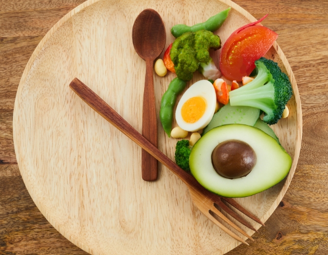 Food on a plate with cutlery arranged like a clock