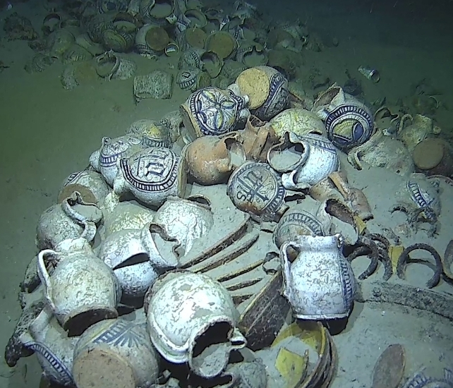 Multiple jugs with intricate designs, on a seafloor