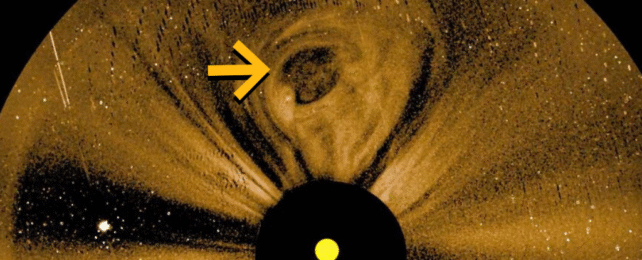 A close image of the sun with a yellow arrow pointing to a spot near the top