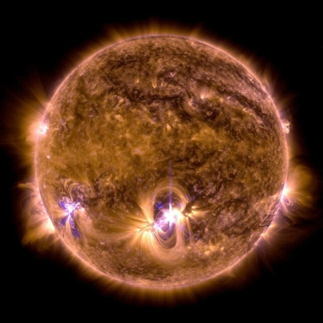 The sun dark red with purple flares