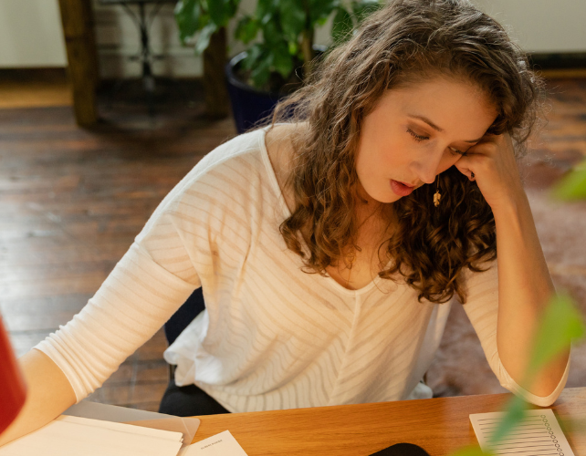 Tired woman sitting at home desk