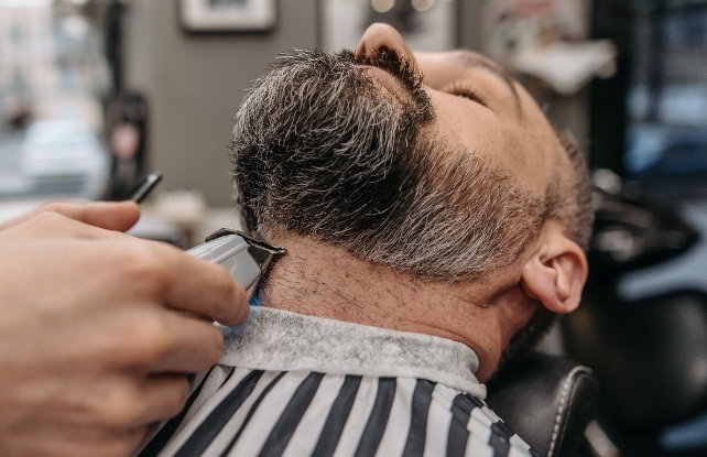 man getting his beard trimmed