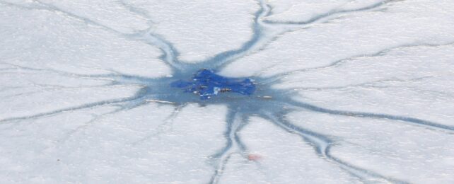 snow-covered cracked ice surface on a frozen lake