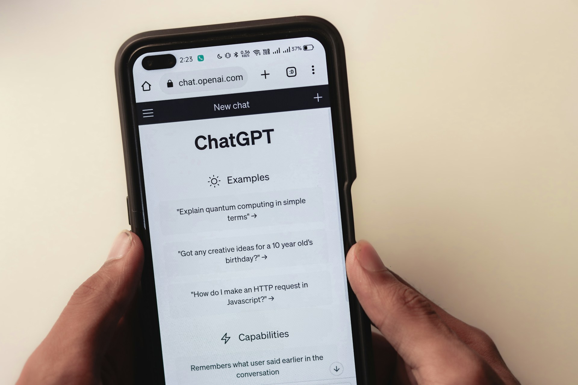 Hands holding mobile phone with ChatGPT on the screen