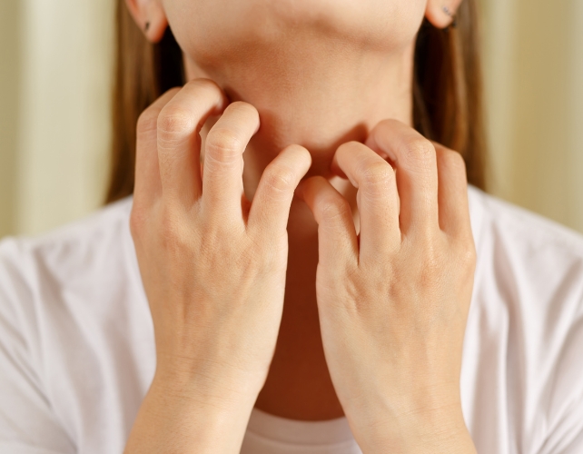 Hands scratch the skin on the neck
