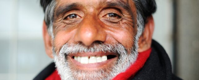 An older man smiling widely