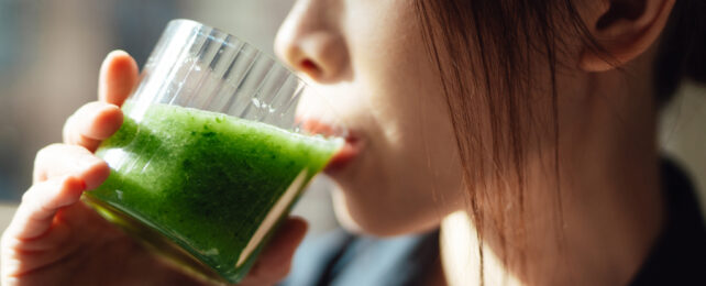 girl drinking green liquid from a glass
