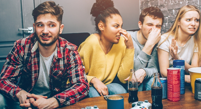 friends of guilty-looking man pulling faces of disgust