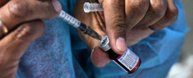 close up of a nurse's hands drawing the measles vaccine from a vial