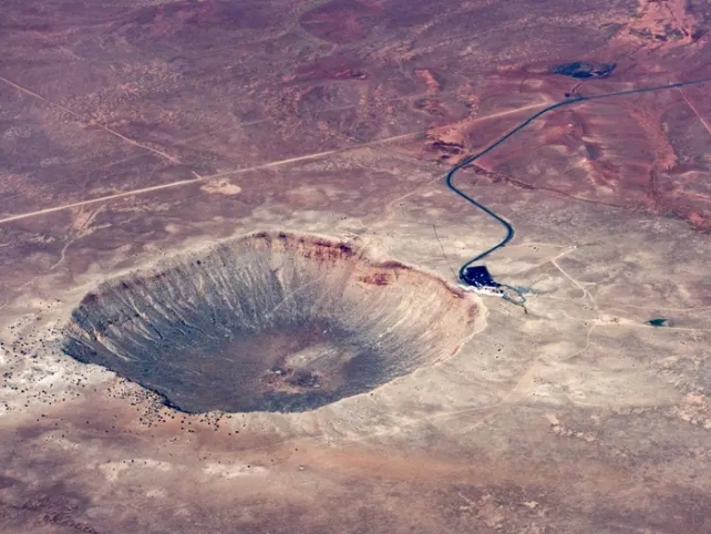 Large meteor crater in barren reddish soil