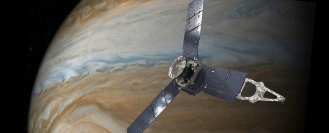 Juno spacecraft in foreground, flying past Jupiter