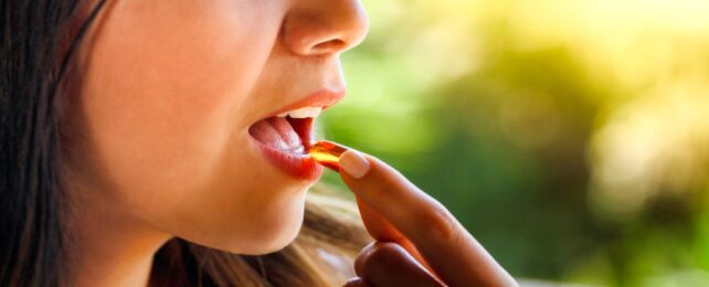Young woman abou to take a pill