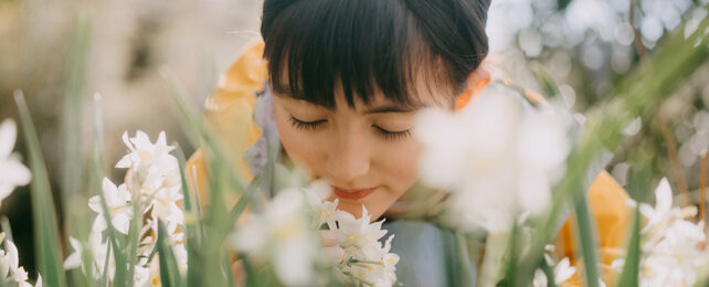 Young woman smelling flowers