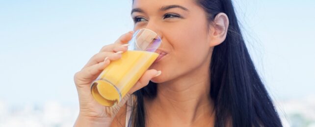 woman drinking orange drink